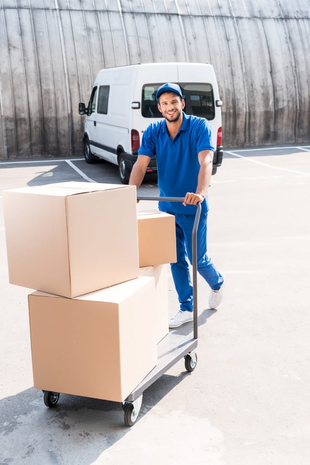 happy-delivery-man-with-cardboard-boxes-on-cart-e1618304324777.jpg